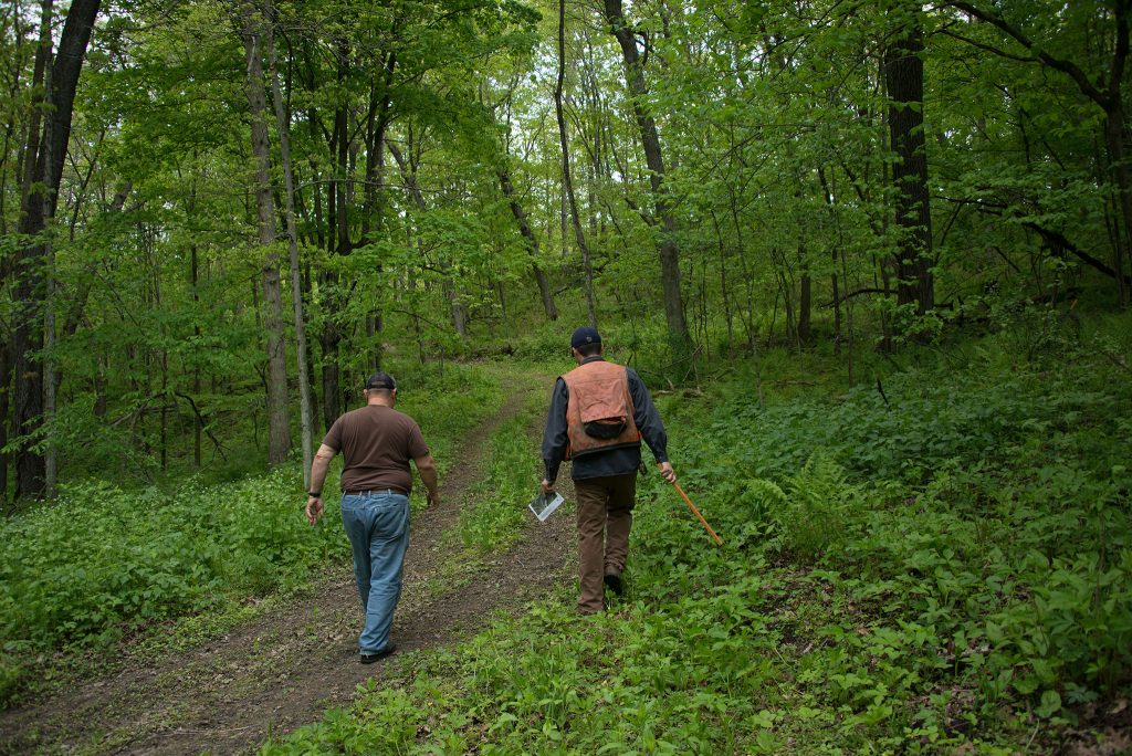 landowner and forester on a trail in the woods