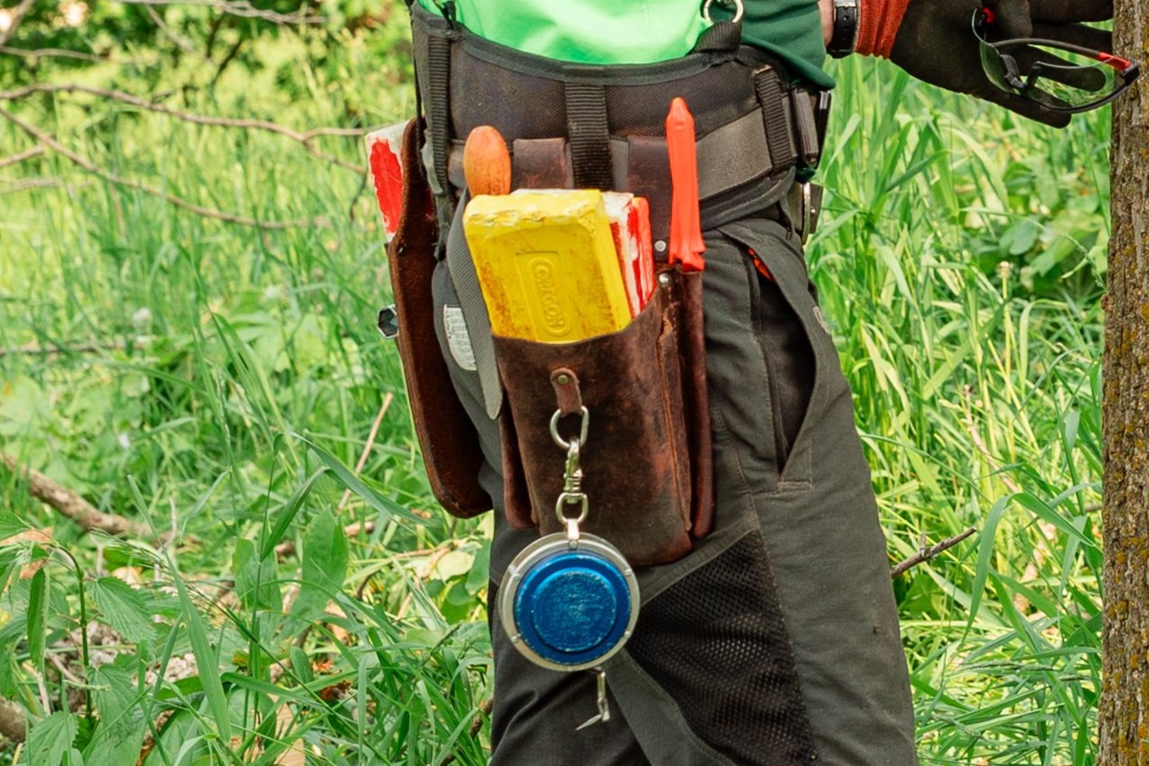 person with a wedge and other chainsaw gear attached to their belt