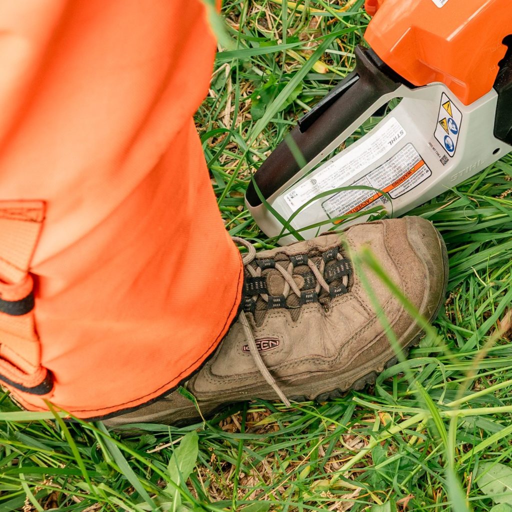 a boot next to a chainsaw