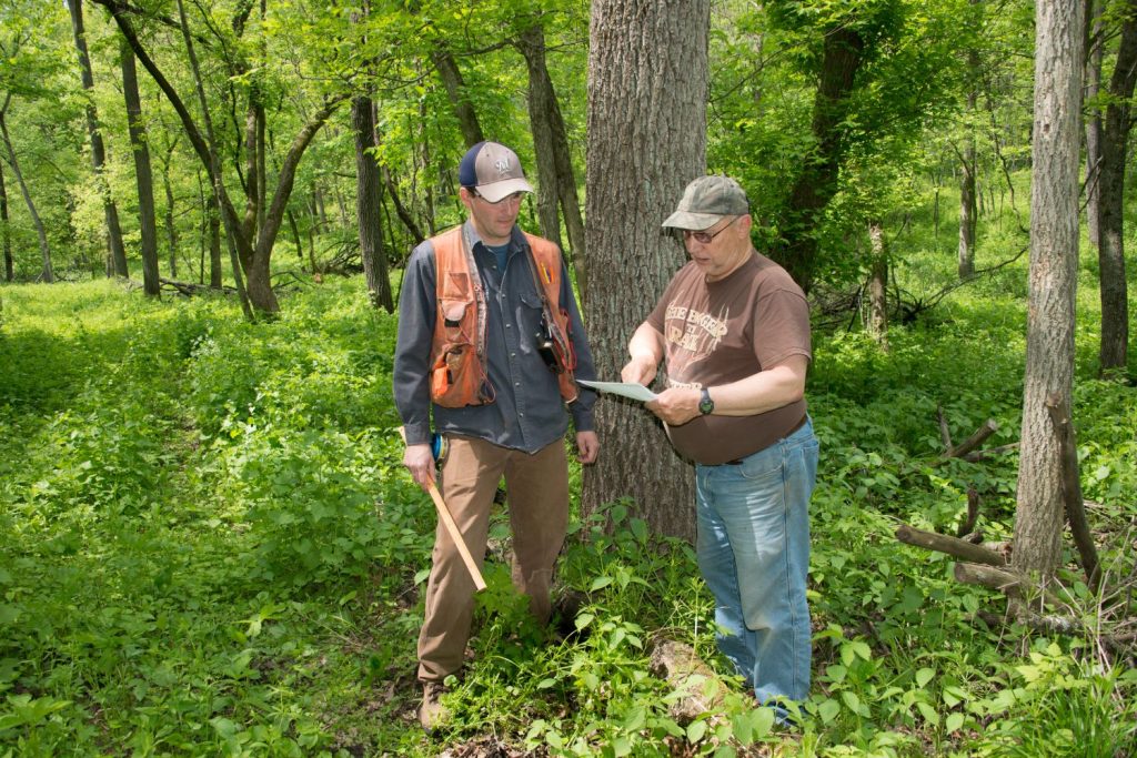 Forester talking with a landowner in the woods