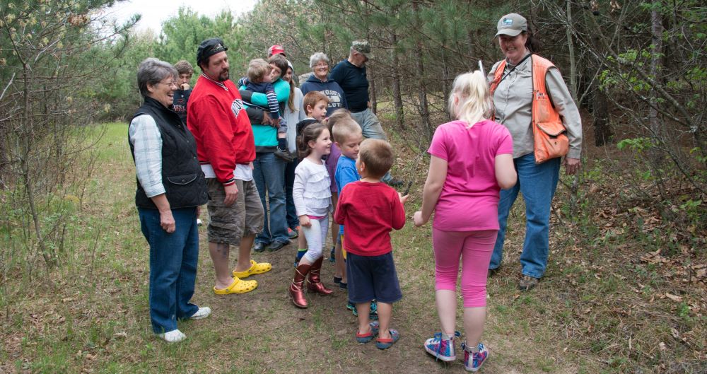 A group of people from multiple generations in the woods
