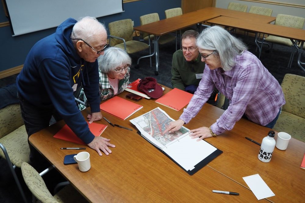 four people looking at a map